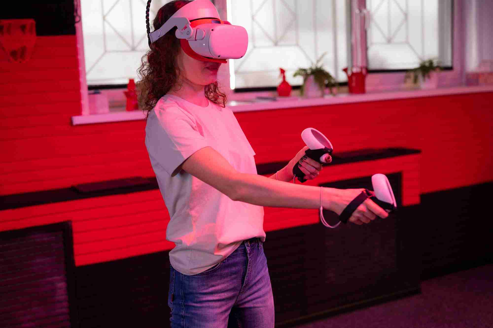vr game and virtual reality. adult woman gamer in goggles playing on shooting simulation video game