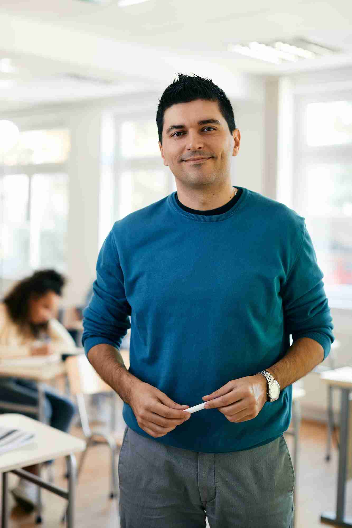 Portrait of male teacher in the classroom at high school.